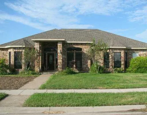 a view of a brick house with a yard