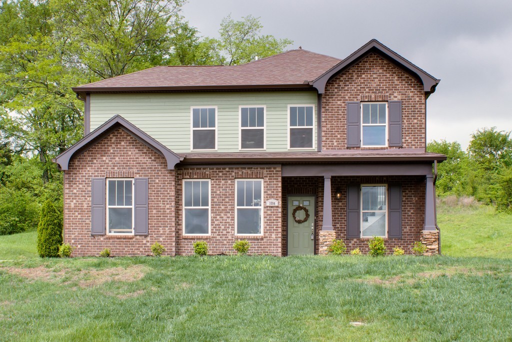 a front view of a house with a garden and yard