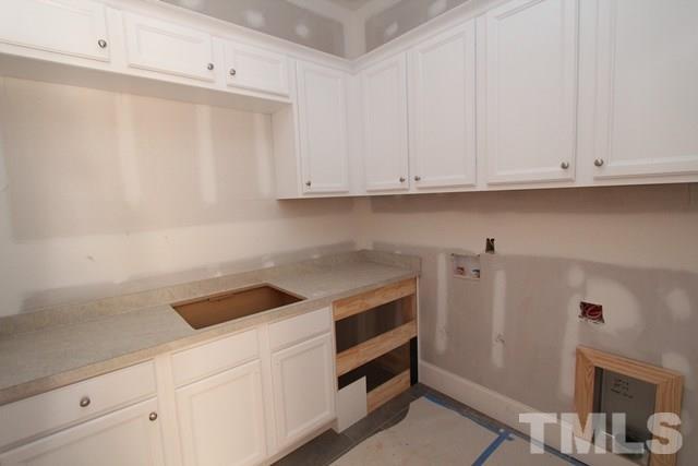 8620 Wapello Lane Raleigh, NC 27613 - Photo 12 of 25 a kitchen with white cabinets and white appliances