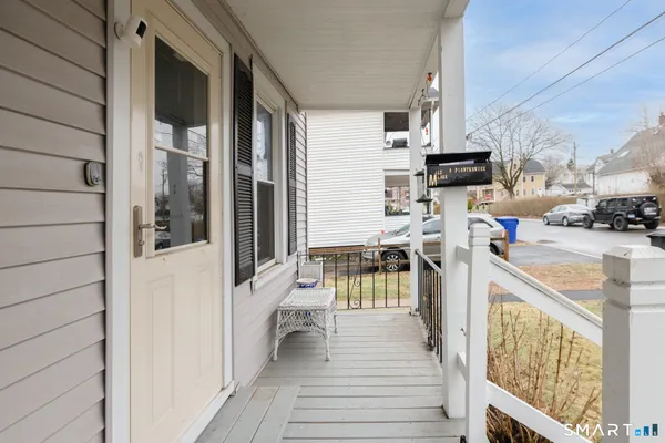 a view of a balcony with furniture and a potted plant