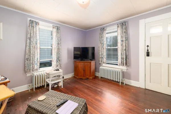 a living room with furniture wooden floor and a flat screen tv
