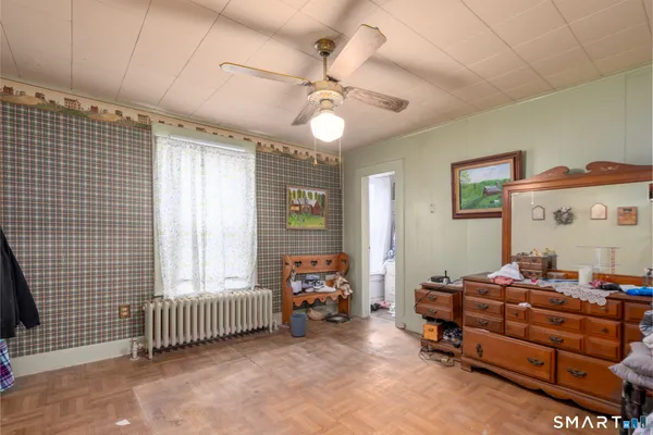 a bedroom with furniture and a large window
