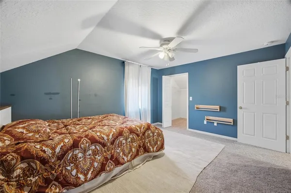 a bedroom with a large bed and a chandelier