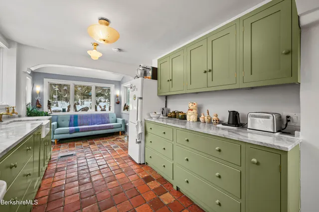 a kitchen with granite countertop a sink a stove cabinets and wooden floor
