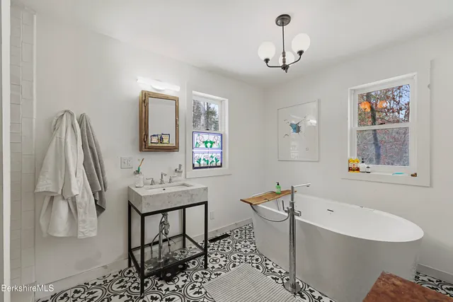 a bathroom with a sink a mirror and a bathtub