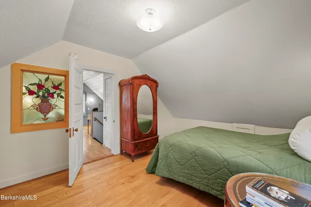 a bedroom with a bed and a painting on the wall