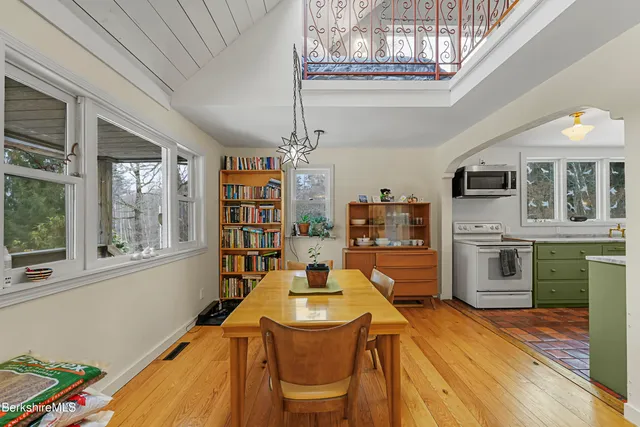a dining room with furniture a kitchen wooden floor and a fireplace