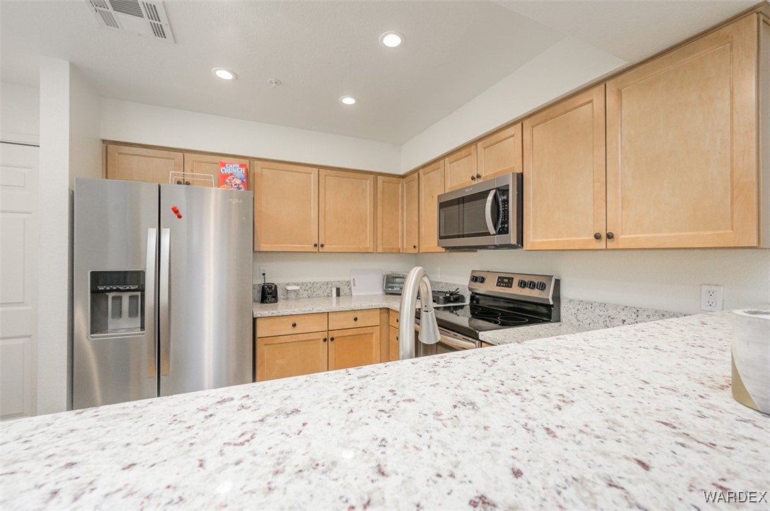 2004 Mesquite Lane, Unit 304 Laughlin, NV 89029 - Photo 10 of 36 a kitchen with granite countertop a refrigerator stove microwave and refrigerator