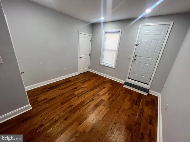 a view of an empty room with wooden floor