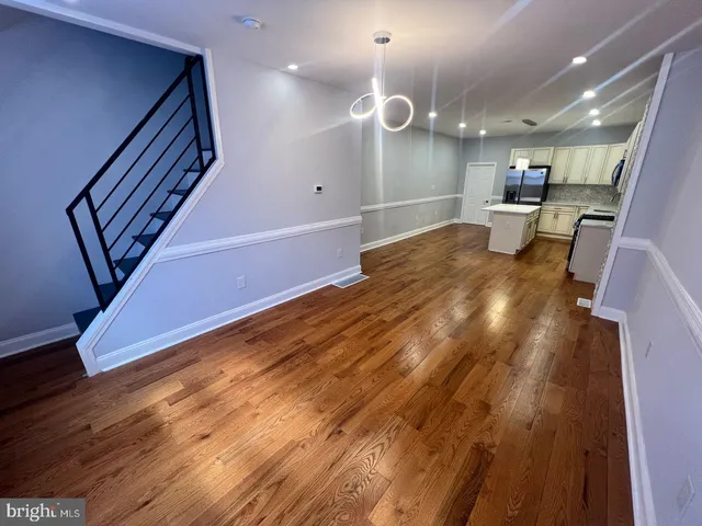 a view of a kitchen with a sink and wooden floor