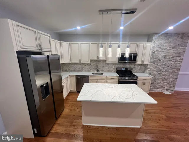 a kitchen with stainless steel appliances a refrigerator sink and microwave