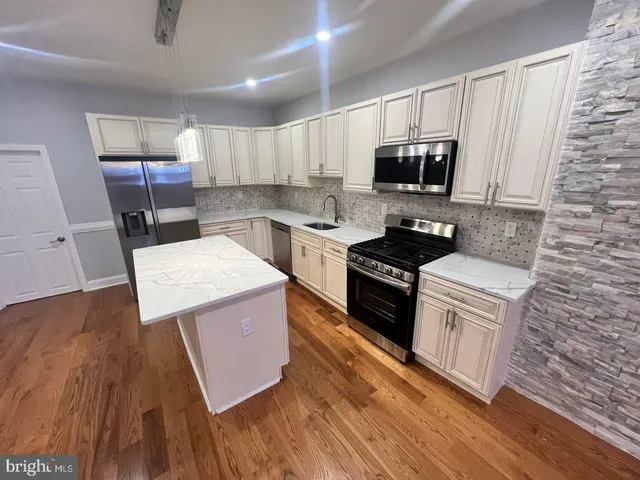 a kitchen with a sink a counter top space stainless steel appliances and a window