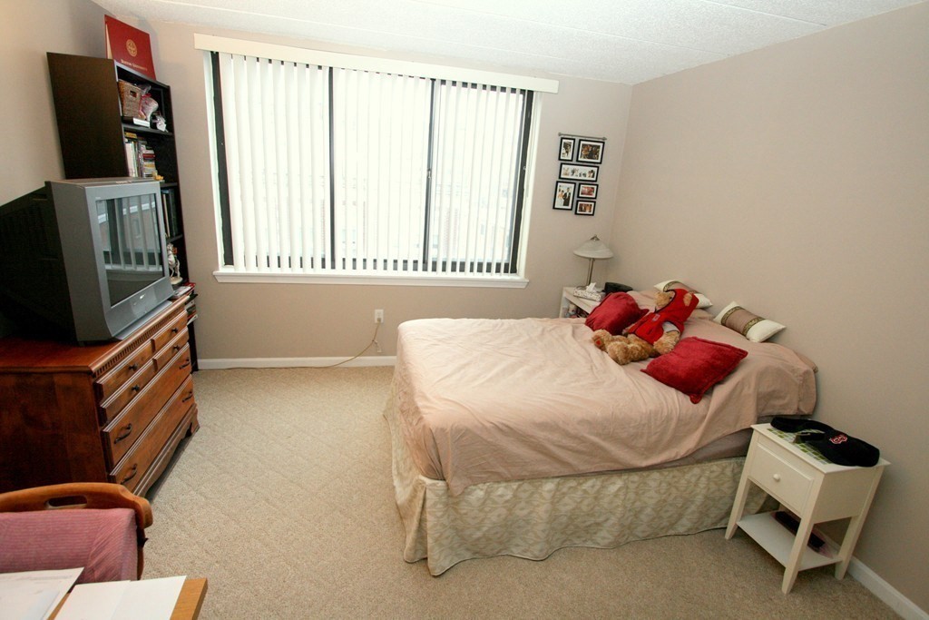 85 Brainerd Road, Unit 510 Boston, MA 02134 - Photo 11 of 25 a bedroom with a bed and flat screen tv