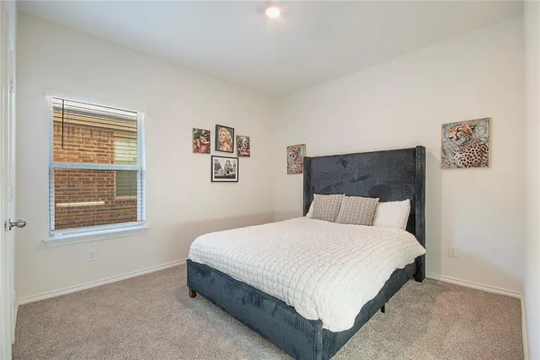 a bed sitting in a bedroom next to a window