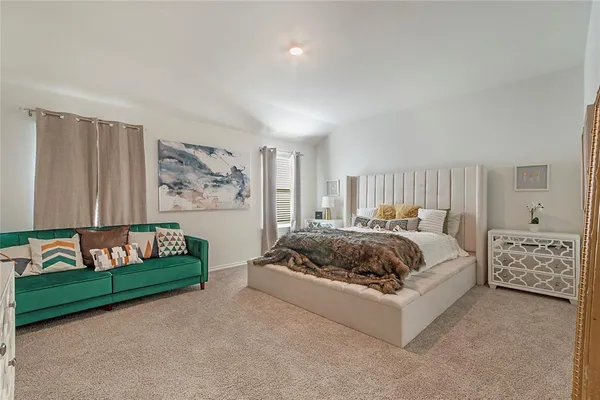 a spacious bedroom with a bed and a couch