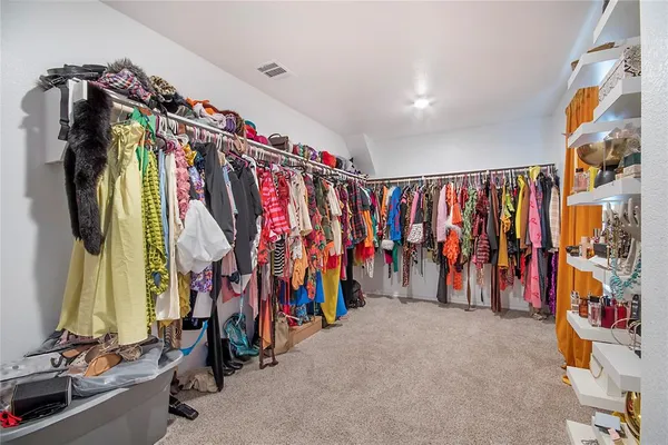 a view of walk in closet with clothes