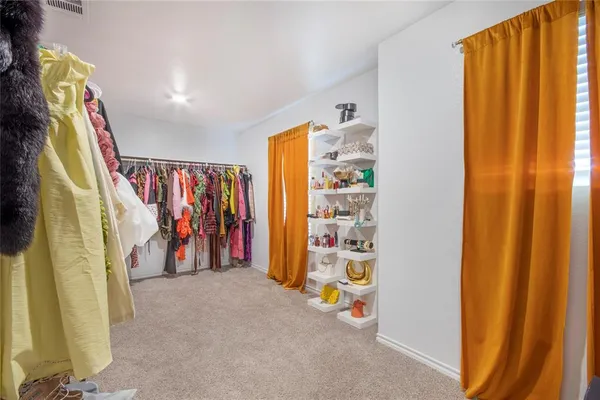 a view of walk in closet with clothes