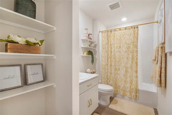 a bathroom with a granite countertop sink a toilet and a shower