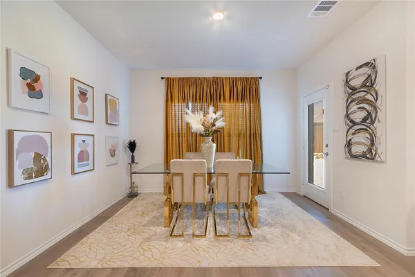 a dining room with wooden floor and a rug