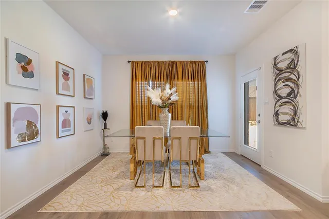 a dining room with wooden floor and a rug