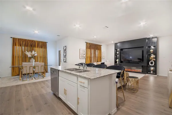 a open kitchen with stainless steel appliances granite countertop a stove and a wooden floors