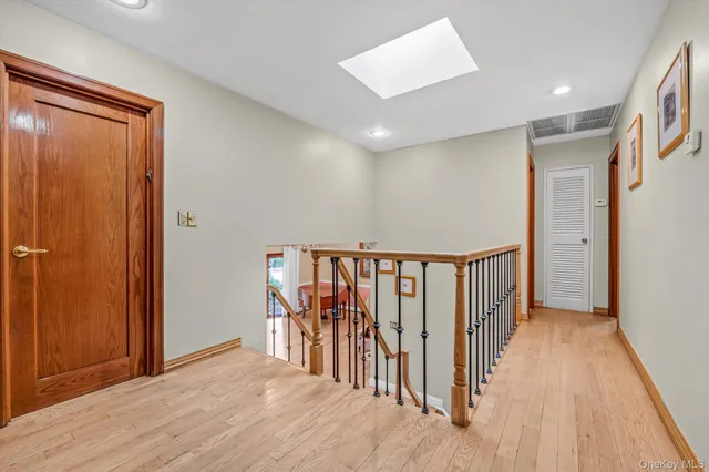 a view of a hallway with wooden floor and closet