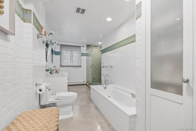 a bathroom with a tub sink toilet and shower