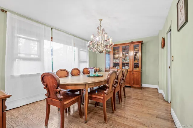 a dining room with furniture a chandelier and wooden floor