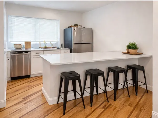 a kitchen with appliances cabinets and wooden floor