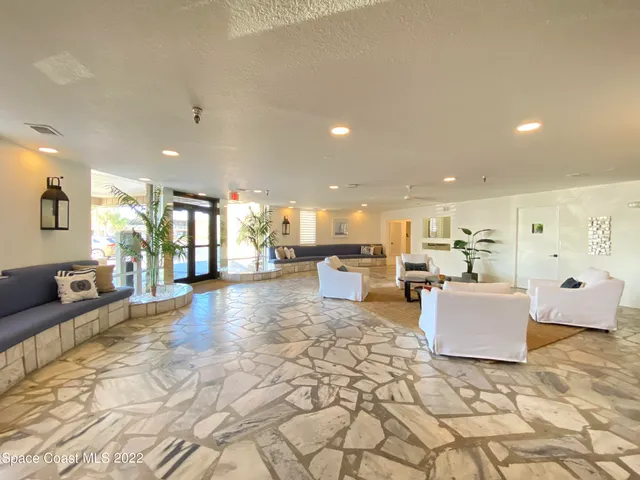 a living room with furniture and a dining table with kitchen view