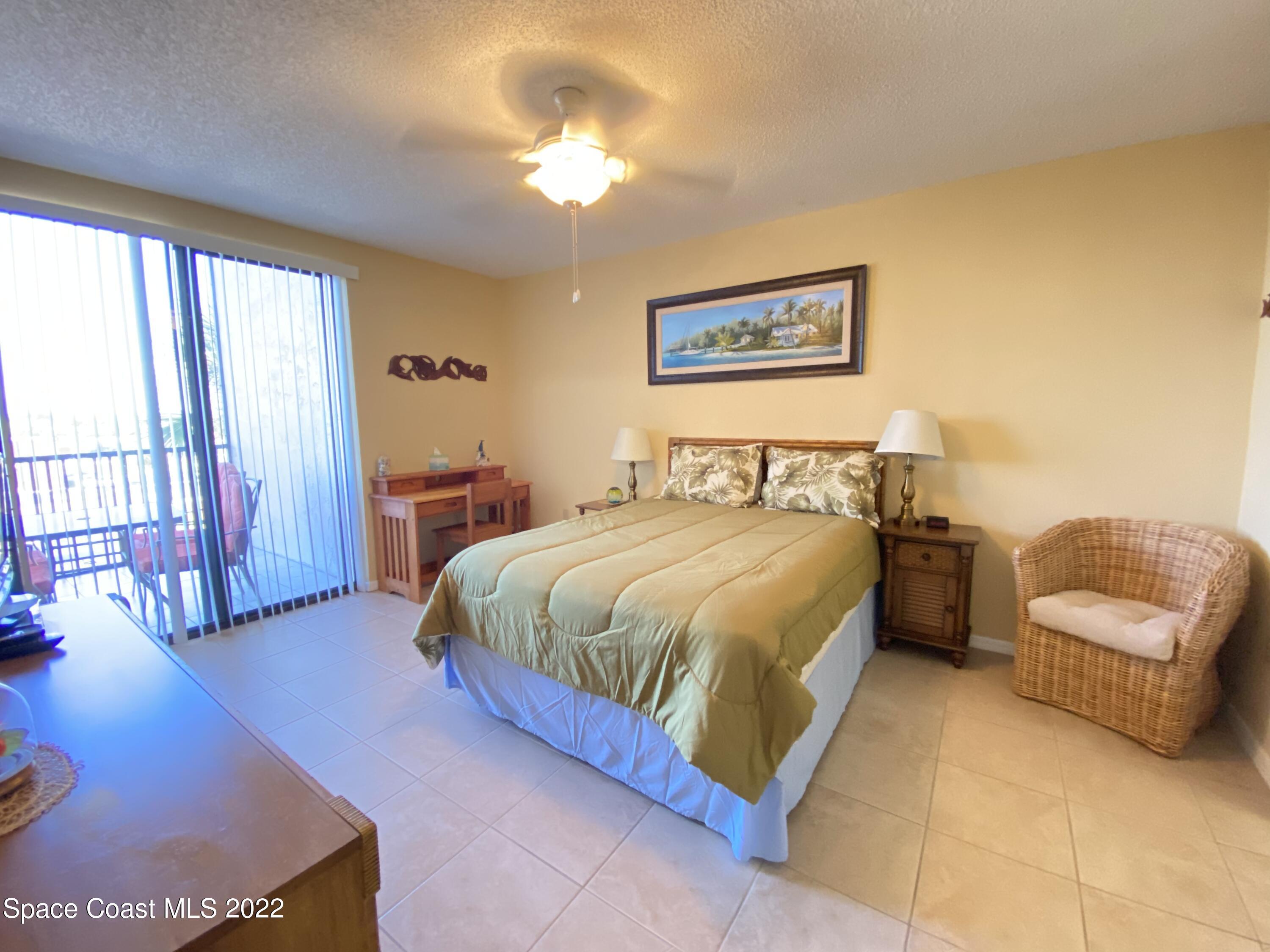 333 North Atlantic Avenue, Unit 305 Cocoa Beach, FL 32931 - Photo 10 of 21 a bedroom with a bed and a couch