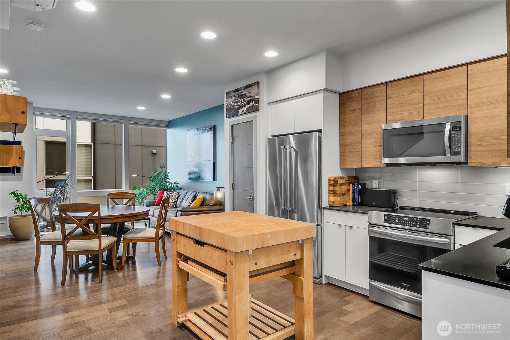 5009 Renton Avenue South, Unit C Seattle, WA 98118 - Photo 8 of 26 a kitchen with stainless steel appliances a stove a refrigerator and a dining table