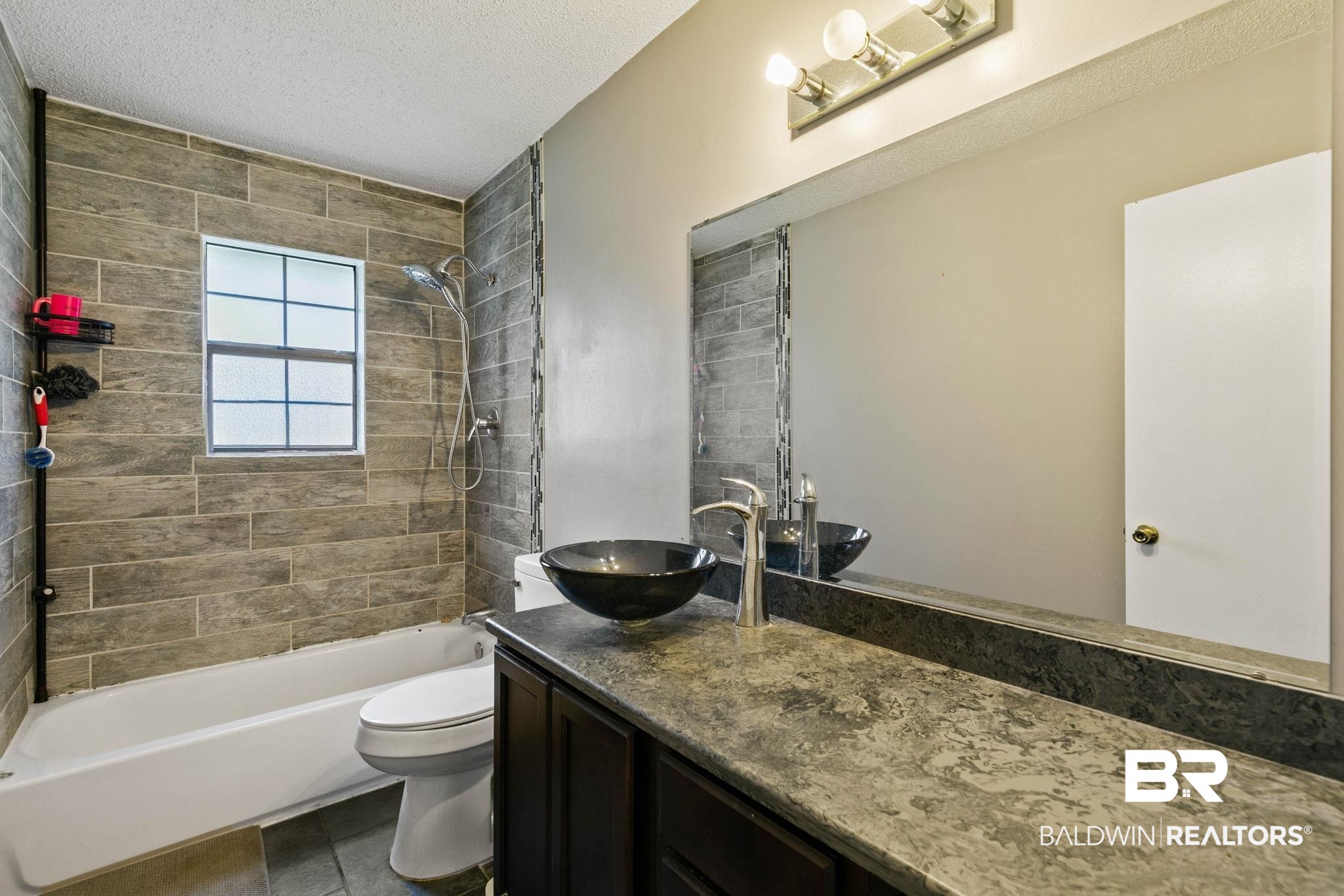 13653 Roberts Road Loxley, AL 36551 - Photo 20 of 33 Bathroom featuring a dark wood-finish vanity with a patterned countertop, a vessel sink, and a large wall-mounted mirror