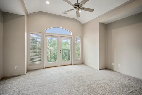 a view of a room with a ceiling fan and closet area