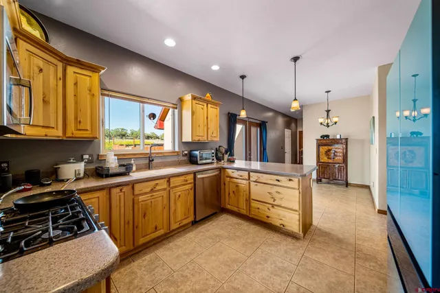 a large kitchen with stainless steel appliances granite countertop a stove a sink and a refrigerator