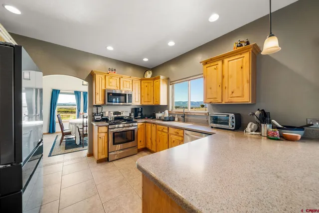 a kitchen with stainless steel appliances granite countertop a sink a stove and a refrigerator