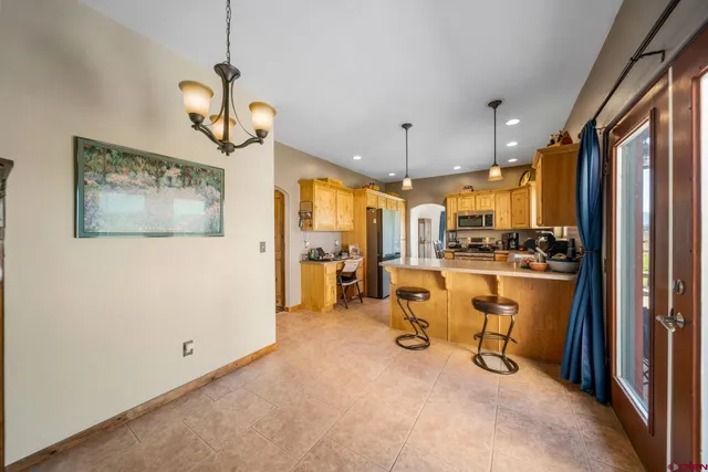 a view of a livingroom with kitchen furniture and a chandelier