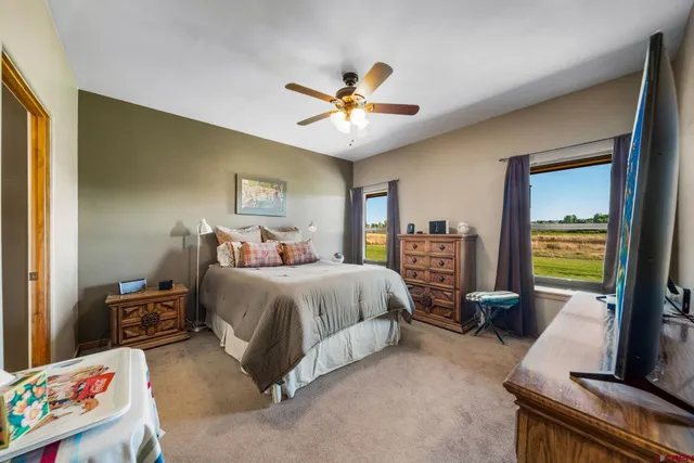 a bedroom with bed and a large window