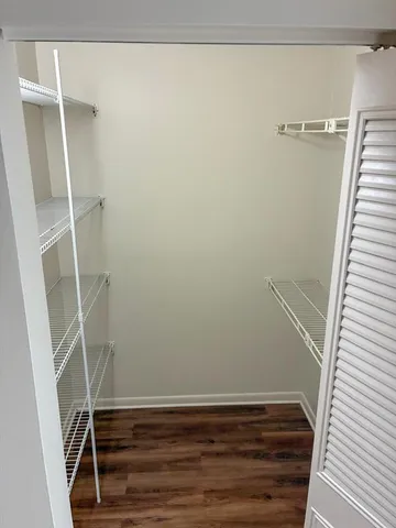a view of a room with wooden floor and a ceiling fan