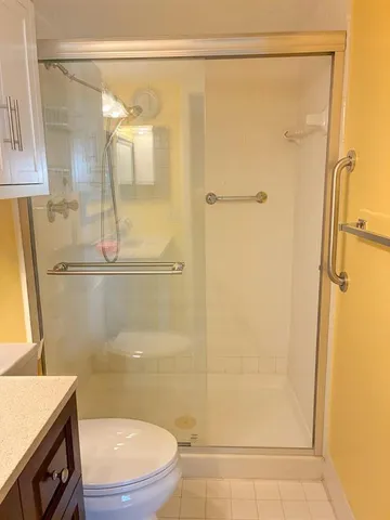 a bathroom with a granite countertop sink toilet and shower