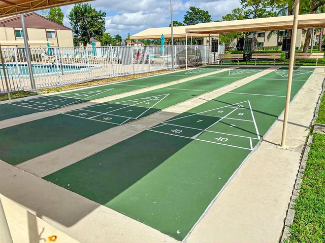 a view of a big white building with a big yard and large trees