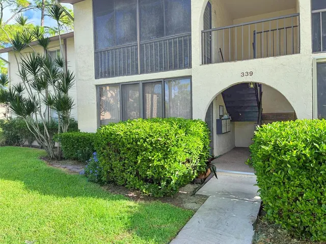 a view of a pathway of a house with a flower garden