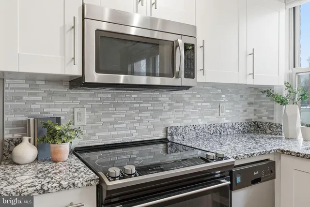 a kitchen with granite countertop a stove and cabinets