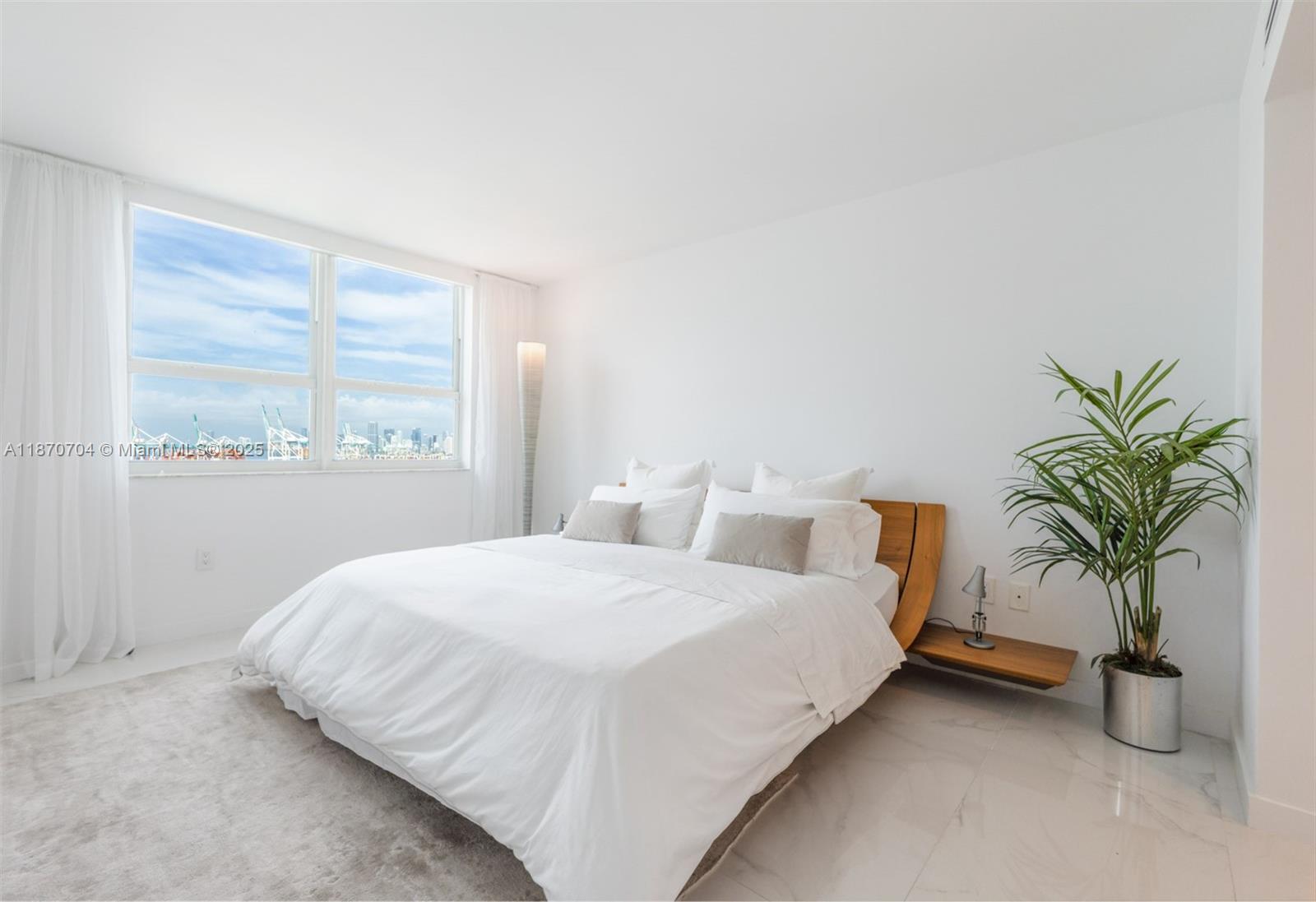 90 Alton Road, Unit 1702 Miami Beach, FL 33139 - Photo 12 of 49 a bedroom with a bed and a large window