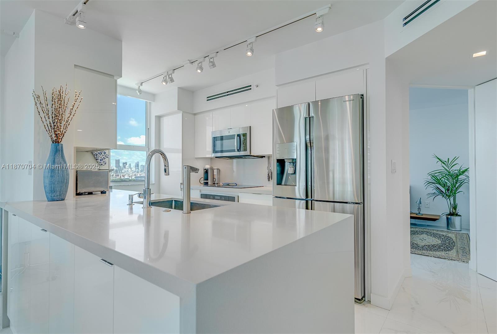 90 Alton Road, Unit 1702 Miami Beach, FL 33139 - Photo 4 of 49 a kitchen with granite countertop a refrigerator and a sink