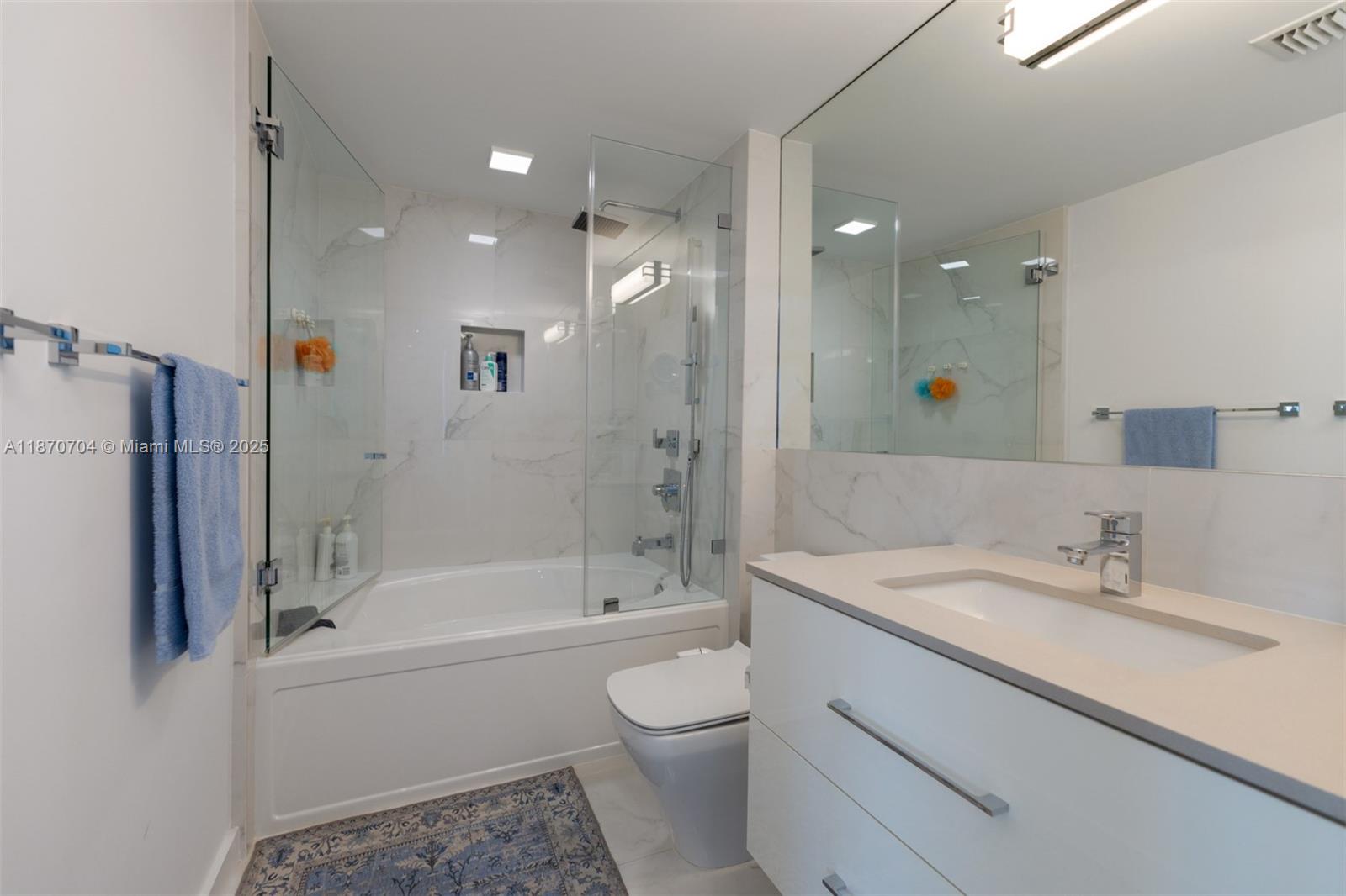 90 Alton Road, Unit 1702 Miami Beach, FL 33139 - Photo 10 of 49 a bathroom with a bathtub shower sink vanity and toilet