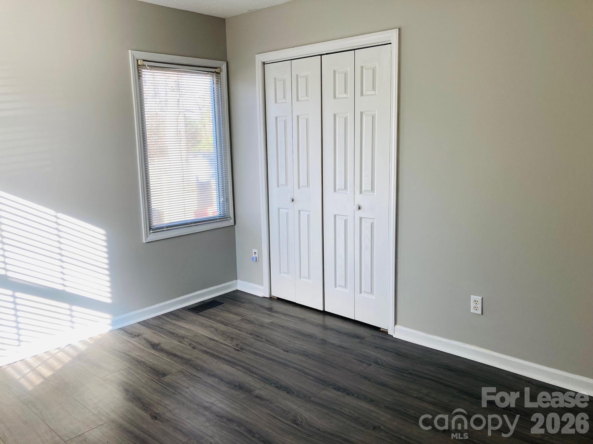 7781 Red Robin Trail Denver, NC 28037 - Photo 14 of 26 an empty room with wooden floor and windows