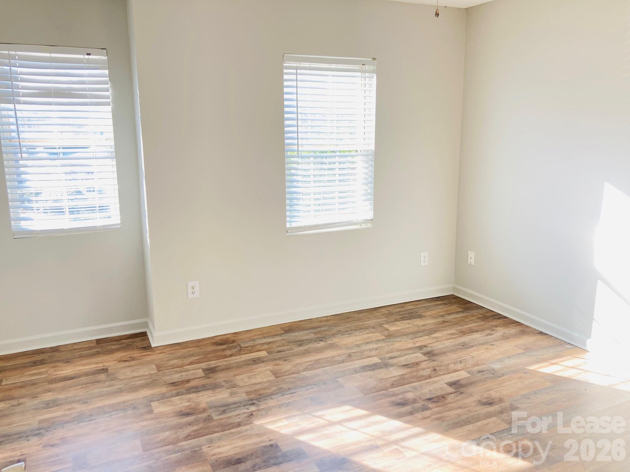 7781 Red Robin Trail Denver, NC 28037 - Photo 19 of 26 an empty room with wooden floor and windows