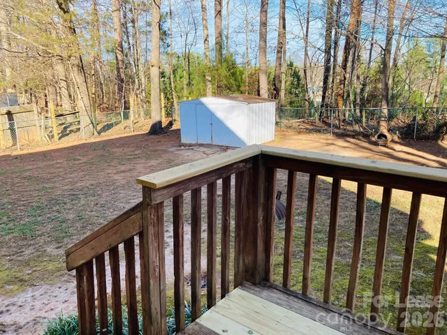 a view of staircase with wooden floor and a bench