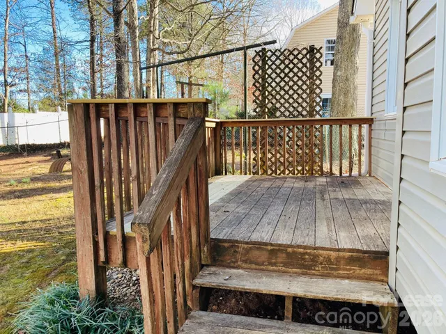 a view of a house with a small yard and wooden fence